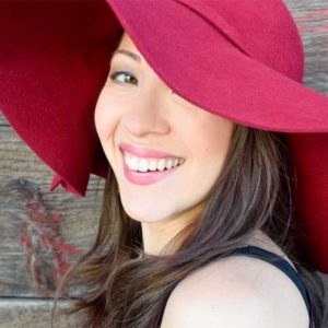Cassandra Hoo is smiling and wearing a red hat